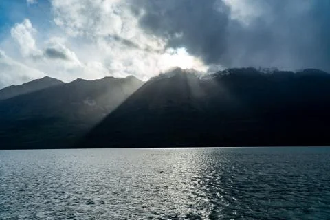 Sun break through clouds at fiord Fotos de archivo