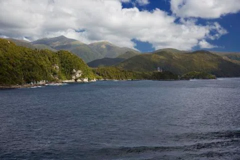 Sun breakes through the clouds at Dusky Sound. Stock Photos