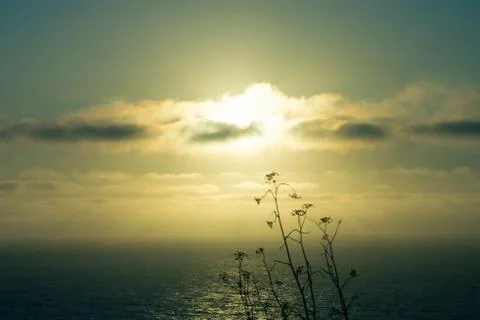 Sun breaking through the clouds above the water Foto stock