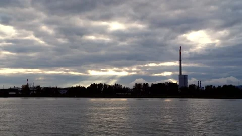 Sun breaking through clouds over industrial plant Video stock 147024772