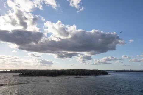 Sun breaking through clouds over water 스톡 사진