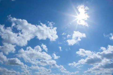 Sun breaking through clouds on a sunny day Stock Photos