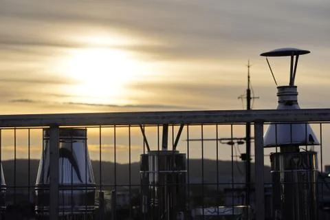 The sun breaking through the clouds, the ventilation pipes on the roof. refle Stock Photos