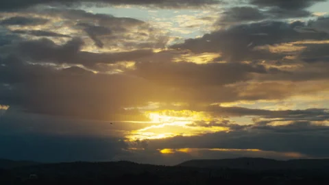 Sun Breaking Through Heavy Evening Clouds Over Distant Hills Stock Footage 344088440