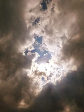 Sun Breaking Through Storm Clouds Over Blue Sky With Rays Of Light And Contrast Stock Photos