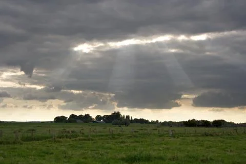 The sun breaks through the clouds over an agriculturally used area in North R Stock Photos