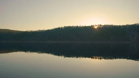 The sun breaks through the trees on the river bank Stock Footage 78706672