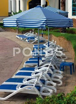 Sun chairs and umbrellas Stock Photos