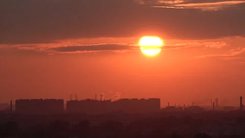 Sun comes down from behind a cloud and sets over the horizon against the Stock Footage 141207711