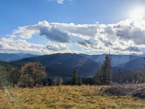 The sun comes out from behind the clouds in a beautiful mountainous area. Stock Photos