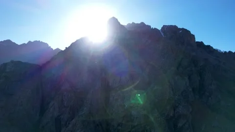 The sun comes out from behind the steep cliffs Vídeos de archivo 212399439