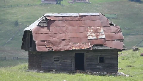 Sun coming over old barn in mountains Stock Footage