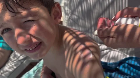 Sun cream concept, Applying sun cream, body milk to children boy in sunny t.. Stock Footage 256244830
