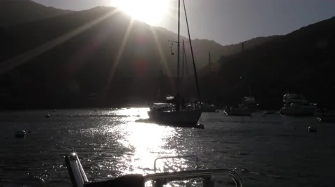 As the sun crests over the island moored yachts glow white in the last light Video stock 67972174