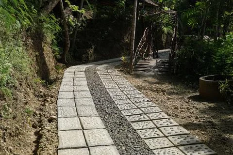 A sun-dappled footpath winds through a grassy landscape, guiding the way fo.. Foto stock