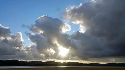 Sun in the dark clouds over river Foto stock
