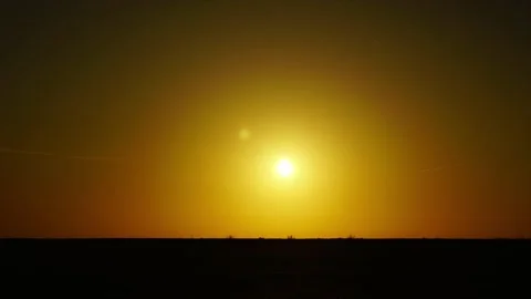 The sun in the desert in a time-lapse sunset over a flat horizon Stock Footage 149253562