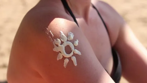 Sun design with sunscreen on a woman's shoulder Stock Footage 313551789