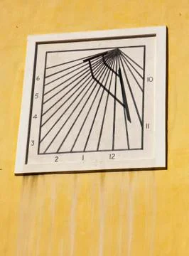 Sun dial on yellow wall Stock-Fotos
