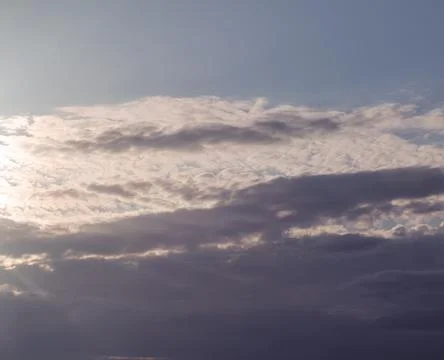 The sun dipping behind an approaching cloud front Stock Photos