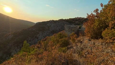 Sun dips behind hills, casting golden light. Soko Grad, Serbia 動画素材 345896291