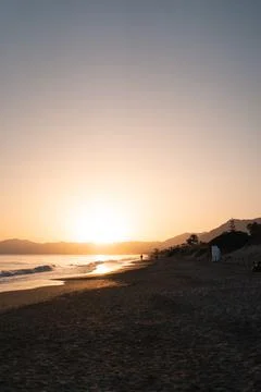 The sun dips below the horizon, casting a calming golden hue over the serene Stock Photos