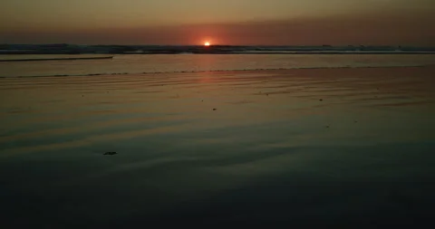 Sun dips below the horizon line along beach 스톡 동영상 138322269