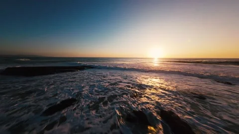 Sun dips below waves, casting golden glow Stock Footage 339789073