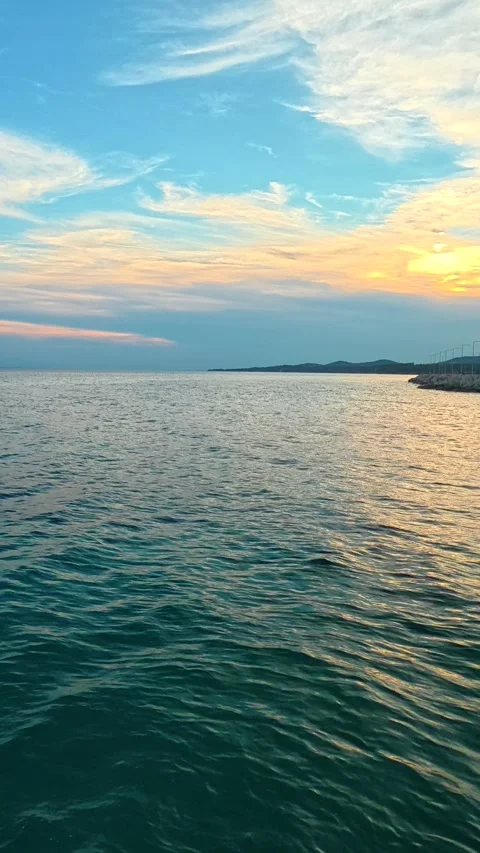 Sun dips slow over calm sea. Nikiti, Greece. Vertical Stock Footage 339628725