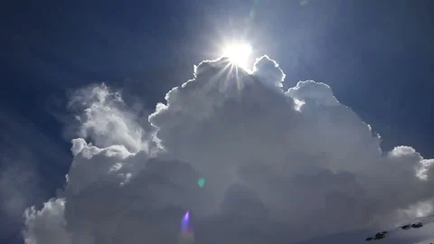 Sun disappearing behind large clouds. Fast motion. Lens flares. Stock Footage 86695014