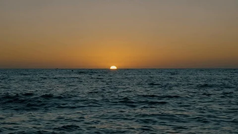Sun disappearing into the horizon Stock Footage 123190042