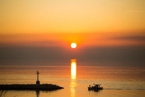 Sun disk reflecting on sea surface, with orange color dominating the seascape Stock Photos