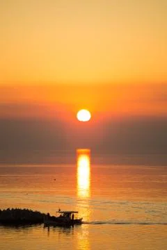 Sun disk reflecting on sea surface, with orange color dominating the seascape Stock Photos