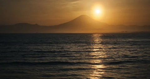 Sun Disk Setting Behind Mount Fuji Peak With Ocean Reflection Video stock 344689980