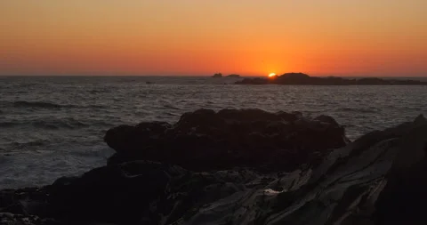 Sun in distance, dipping below horizon at sunset on the ocean Stock Footage 131899207