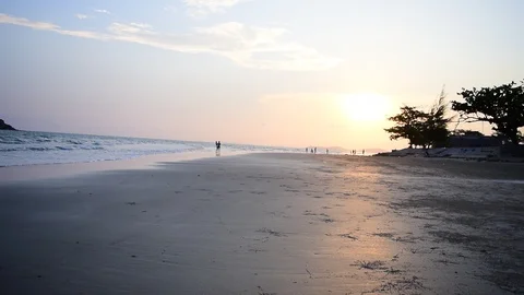 Sun is down by the beach, along with streaky waves of the sea. Stockbeeldmateriaal 87277067