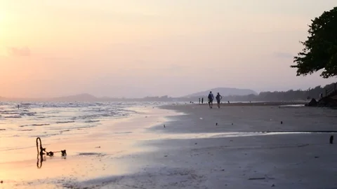 Sun is down by the beach, along with streaky waves of the sea. Stockbeeldmateriaal 87277107