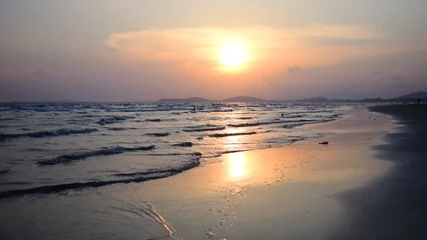 Sun is down by the beach, along with streaky waves of the sea. Stockbeeldmateriaal 87277252