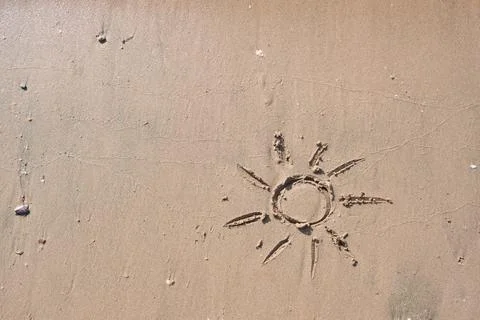Sun drawn in sand on empty tropical beach during sunset. Vacation and Travel  Stock-Fotos