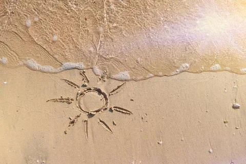 Sun drawn in sand on empty tropical beach during sunset. Vacation and Travel  Stock-Fotos