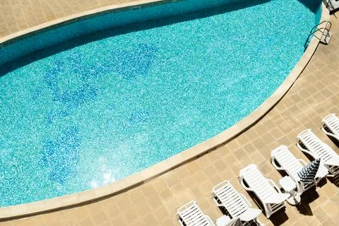 Sun-Drenched Poolside Serenity: A Tranquil Oasis for Relaxation and Recreation Stock Photos