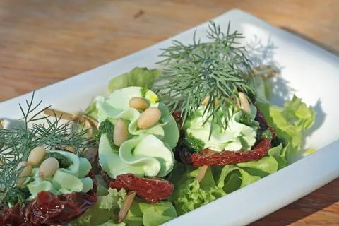 Sun dried tomatoes with butter, pine nuts and herbs. Food and dishes. Useful and Stock Photos