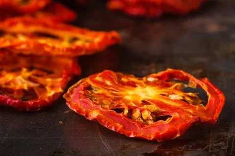 Sun dried tomatoes on dark rustic background Stock Photos