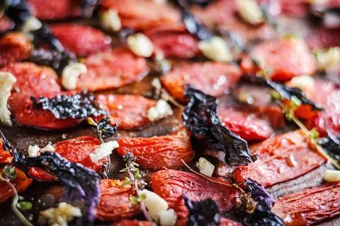 Sun-dried tomatoes with spices on baking sheet Stock Photos