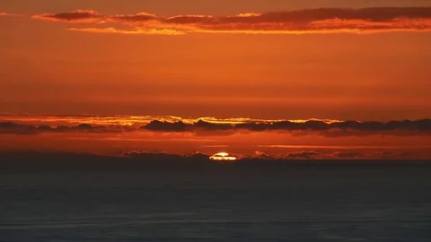 Sun drops below ocean horizon orange clouds 動画素材 79695819