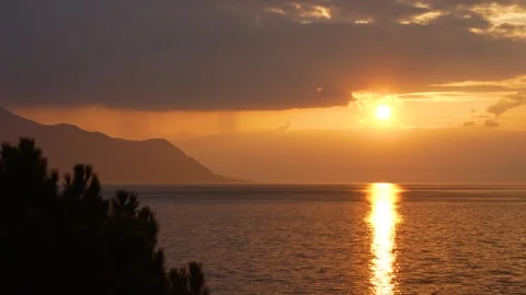 The sun drops through a band of cloud over Lake Geneva at Montreux Stock-Footage 346345046