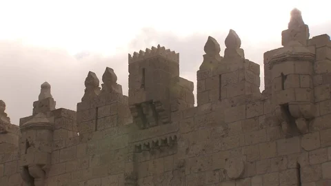 Sun emerges from behind battlement of Old City wall in Jerusalem Stock Footage 86759069