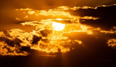 The Sun Falling Behind clouds. A Spectacular golden Sunset Stock Photos