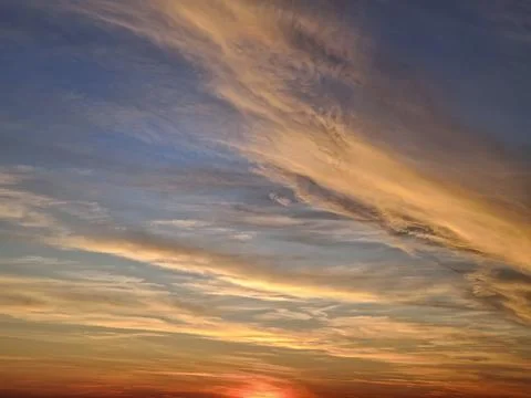 The sun final rays cast a fiery red and orange glow at horizon. Wispy cirru.. Stock Photos