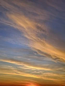 The sun final rays cast a fiery red and orange glow at horizon. Wispy cirru.. Stock Photos